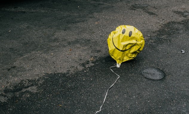 deflated yellow smiley face balloon